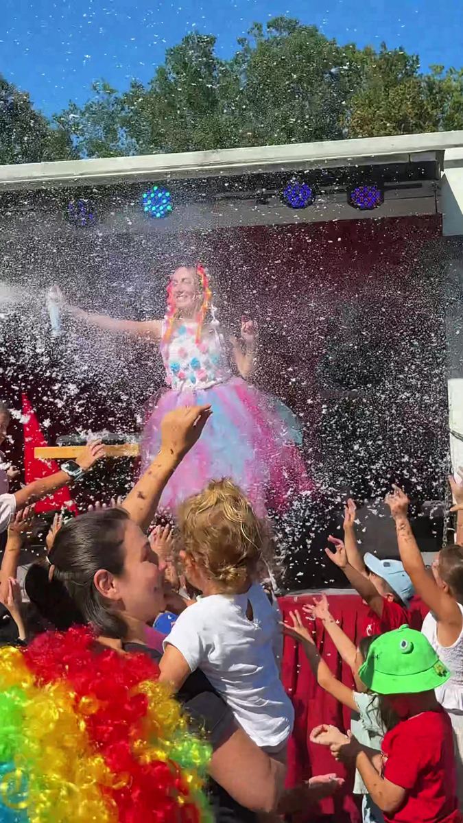 Sahnedeki bubble show sırasında köpüklere uzanan çocuklar
