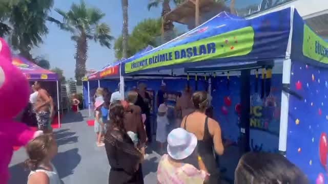Yan yana dizilmiş renkli festival stantları ve kalabalık